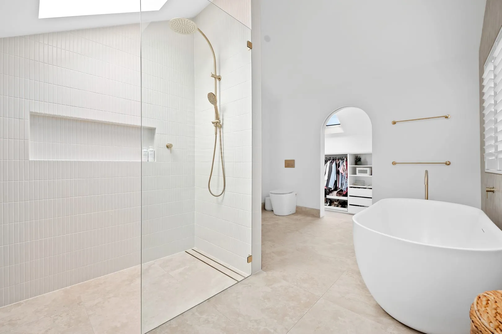 Walk-in shower beside the arched robe entry